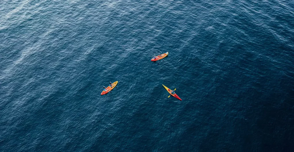 Kayak en mer en Corse sortie au large Trois kayaks colorés vus du ciel naviguant sur la mer en Corse, près des plages de Moriani