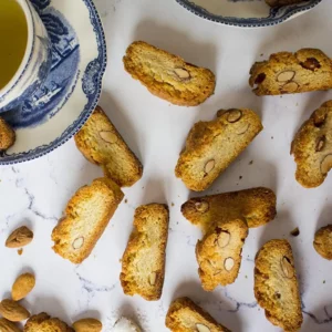 Canistrelli biscuits corses traditionnels Canistrelli corses aux amandes disposés autour d’une tasse de thé sur une table. Souvenir de Corse authentique et gourmand